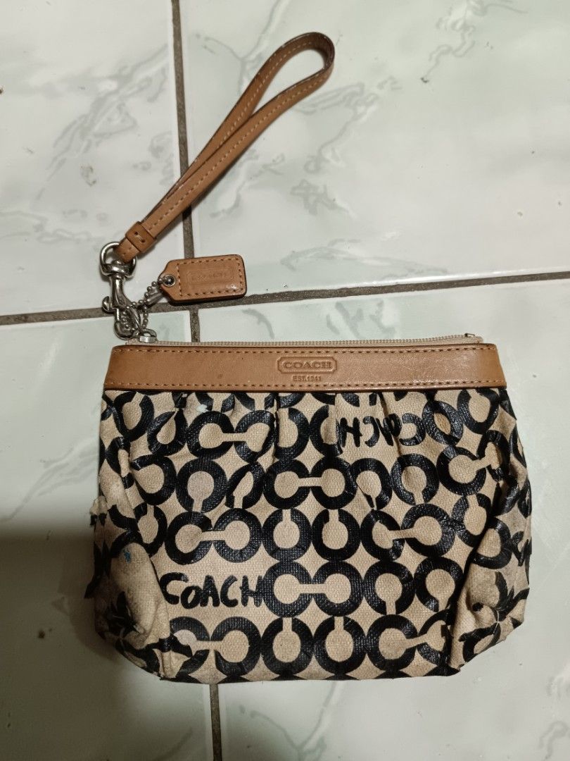 Coach Monogram Wristlet Pouch (Category: Purses & Pouches) located in Manila. Submitted by caaths_collection (Listing ID 1463844900, Image 1). Description: PLS check all picture - Coach monogram wristlet pouch - Classic tan and black pattern with leather trim - Secure zipper closure - Interior lined in blue - Shows some signs of wear on exterior fabric and leather - Ideal for carrying your daily essentials - AS IS.