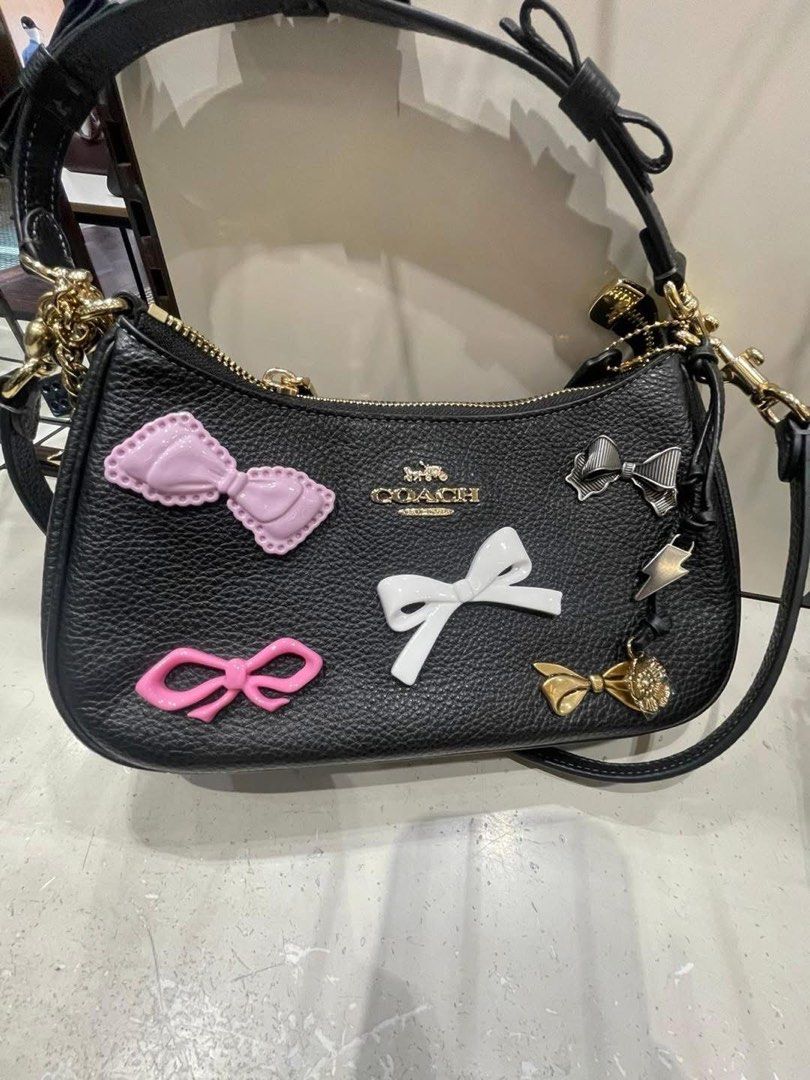 Coach Teri with Bow Charms (Category: Luxury Bags & Wallets) located in Abucay. Submitted by erindeclutterss (Listing ID 1463857504, Image 1). Description: - Authentic -Complete Inclusions - Includes a detachable crossbody strap for versatile wear - Elegant gold hardware details - Comes with a few adorable charms already attached.