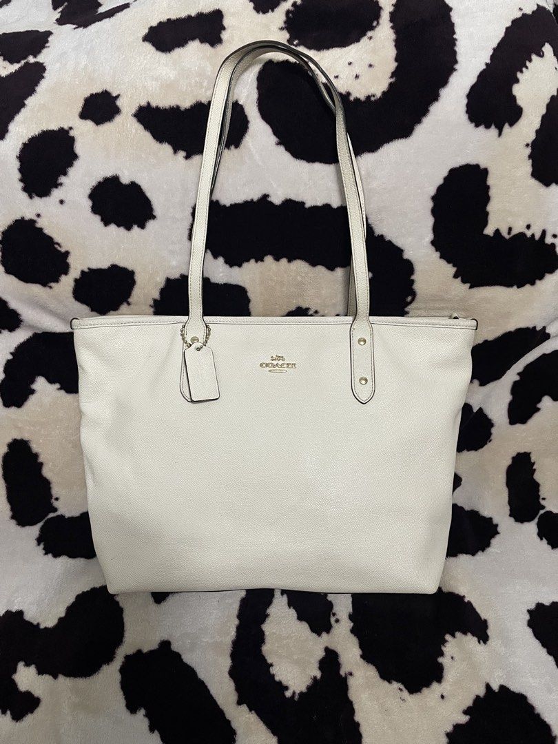 Coach White Leather Tote Bag (Category: Luxury Bags & Wallets) located in Cagayan de Oro. Submitted by luxieebags (Listing ID 1463928792, Image 1). Description: - Authentic Coach white leather tote bag - Classic and timeless design - Comfortable shoulder straps for easy carrying - Features prominent Coach logo and leather tag - Ample interior space for all your essentials - Ideal for everyday use and versatile styling.