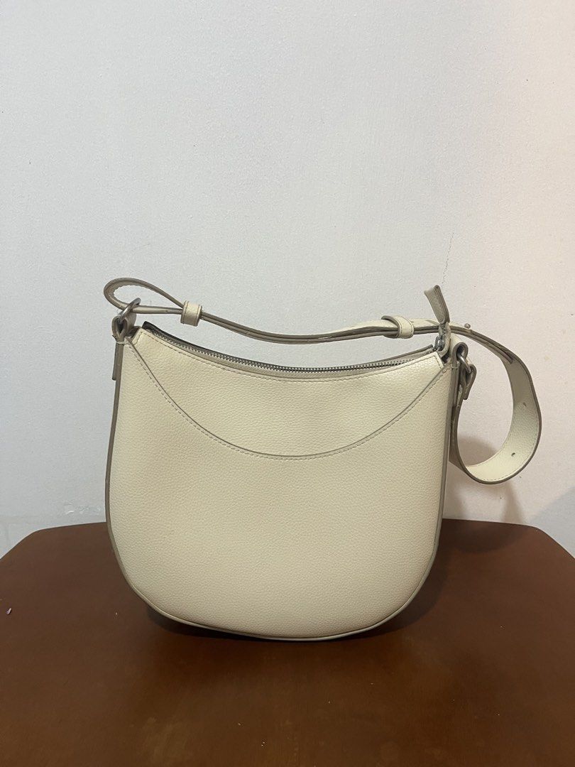 Cream Shoulder Bag (Category: Shoulder Bags) located in Manila. Submitted by samgyup05 (Listing ID 1463789920, Image 1). Description: - Cream shoulder bag with a chic curved design. - Secure zip closure to keep your essentials safe. - Adjustable strap for comfortable, customized wear. - Interior pocket for small item organization. - Note: Some faint marks are present inside the bag..