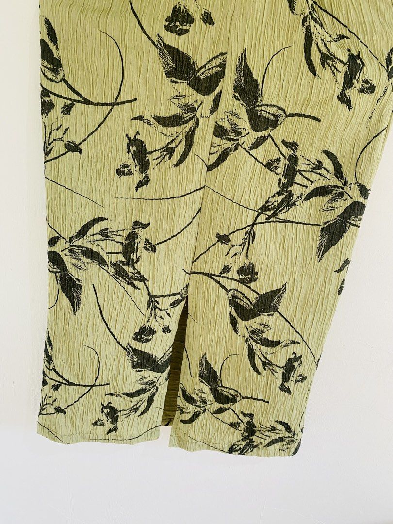 Crinkled Leaf Print Midi Skirt with Slit (Category: Skirts) located in Vigan. Submitted by yourcloset1001 (Listing ID 1463911387, Image 2). Description: - Light green midi skirt - Crinkled texture all over - Black leaf and vine print - Small slit at the front hem - Pull-on style - Versatile for casual or dressed-up occasions.