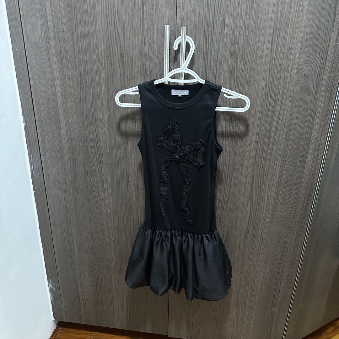 District One Black Coquette Bow Dress (Category: Dresses) located in Pasig City. Submitted by prettygirlmantra (Listing ID 1463872177, Image 2). Description: - Worn once. Bought from District One Vietnam - Elegant black sleeveless dress - Features a delicate lace bow detail on the front - Stylish bubble hem skirt - Estimated size: Medium (M) - Ideal for evening events, parties, or a night out - Comfortable and fashionable design.