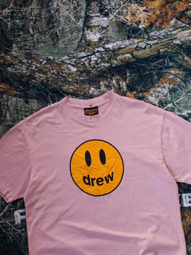 Drew shirt (Category: Tshirts & Polo Shirts ) located in Sugbongcogon. Submitted by yan.drip (Listing ID 1463876983, Image 2). Description: Brand:Drew Housem (founded by Justin Bieber) Style: Mascot Short-Sleeve T-Shirt Color: Dusty Rose / Pale Pink / Light Pink Graphic: Yellow Smiley Face "Mascot" print Fit: Relaxed, oversized streetwear silhouette Features: Ribbed crewneck collar, heavy-grade premium cotton fabric, embroidered/woven brand logo 