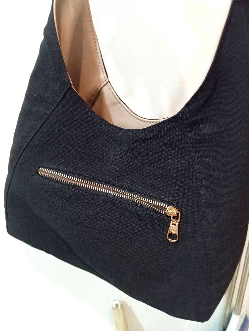 Eve & Adam Reversible Bag (Category: Shoulder Bags) located in Manila. Submitted by cococlo_ (Listing ID 1463832541, Image 2). Description: - Black canvas hobo bag from Eve & Adam - Relaxed, slouchy shape - Light tan interior lining - Front zippered pocket with gold-toned zipper pull - Simple and practical design.
