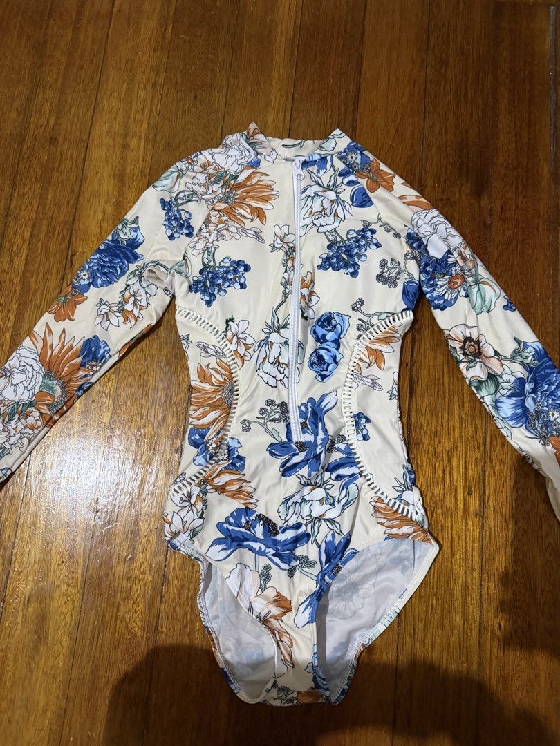 Floral Long Sleeve Rashguard (Category: Rash guard) located in Paranaque City. Submitted by declutternsell.729 (Listing ID 1463775992, Image 2). Description: - Long sleeve rashguard with convenient zip-up front. - Eye-catching floral print featuring blue, orange, and white flowers. - Trendy side cut-out details for a stylish look. - Ideal for swimming, sun protection, beach days, and pool time. - Comfortable and practical design. NEVER BEEN USED.