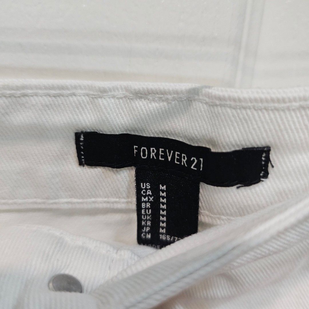 Forever 21 White Button-Up Denim Skirt (Category: Skirts) located in Makati City. Submitted by goldenbird.001 (Listing ID 1463887376, Image 2). Description: - White denim skirt from Forever 21 - Button-up front - Raw hem detail - Estimated size: Medium - Ideal for casual styling - Versatile piece for various outfits.