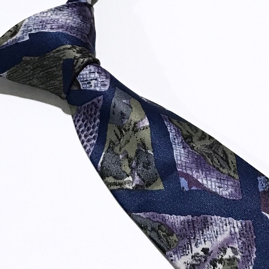 Fossano Elegance Navy Blue Abstract Pattern Neck Tie (Category: Ties) located in Taguig. Submitted by retrogaze (Listing ID 1463819510, Image 1). Description: This classic necktie by Fossano Elegance features a deep navy blue base with a matte, textured finish. The body displays a bold abstract geometric pattern composed of angular, stained-glass style panels. These mosaic sections incorporate a variety of woven and printed textures—including mes