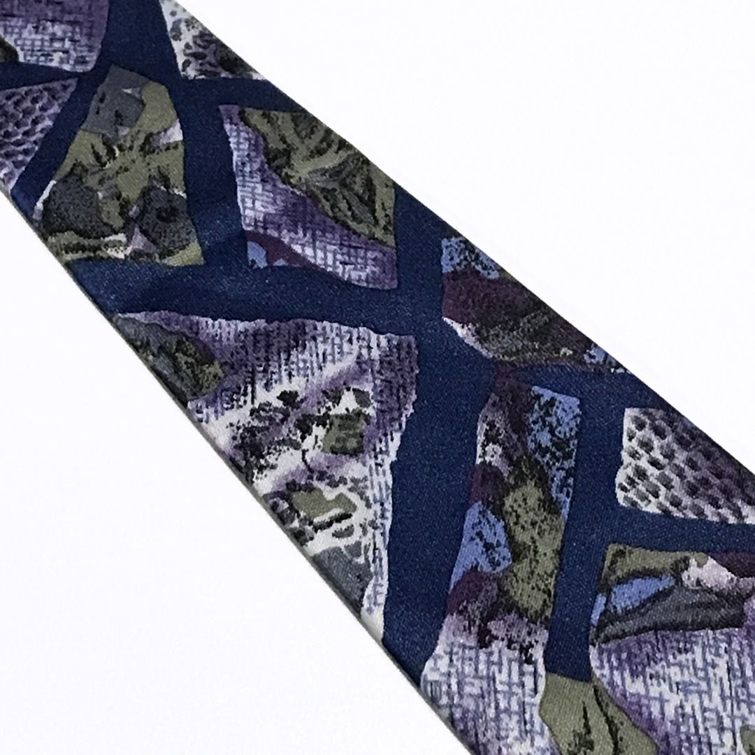 Fossano Elegance Navy Blue Abstract Pattern Neck Tie (Category: Ties) located in Taguig. Submitted by retrogaze (Listing ID 1463819510, Image 3). Description: This classic necktie by Fossano Elegance features a deep navy blue base with a matte, textured finish. The body displays a bold abstract geometric pattern composed of angular, stained-glass style panels. These mosaic sections incorporate a variety of woven and printed textures—including mes