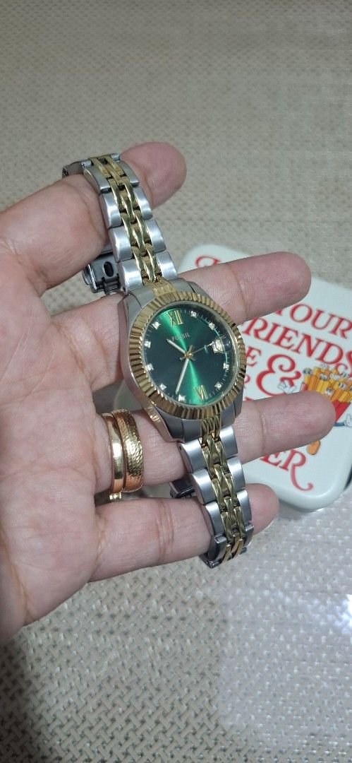 Fossil Two-Tone Watch with Green Dial (Category: Women's Watches) located in Bulacan. Submitted by mymeelhet (Listing ID 1463789334, Image 1). Description: - Two-tone stainless steel and gold-colored band - Classic green dial with Roman numerals - Convenient date window - Original Fossil tin included - Fossil logo on clasp - Versatile for everyday or dressy wear.