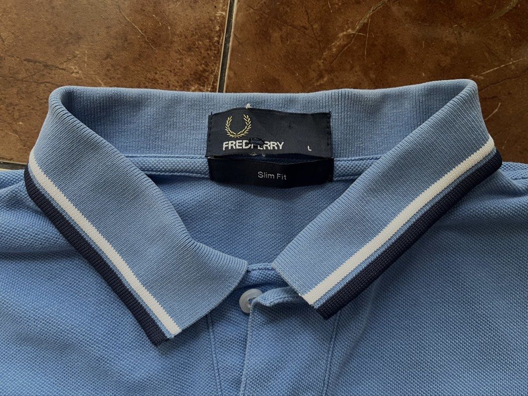 Fred Perry Slim Fit Polo Shirt (Category: Tshirts & Polo Shirts ) located in Angeles City. Submitted by thrift2ac (Listing ID 1463809530, Image 3). Description: Authentic Fred Perry Twin Tipped Polo Size: Men’s Large (Slim Fit). Condition: Great pre-owned condition. Color rate: 9.5/10. Details: Features the iconic navy embroidered laurel wreath logo on the chest and classic twin tipping on the collar and cuffs. Note: Actual item color may vary sl