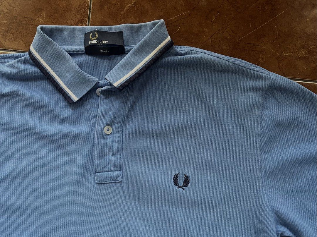 Fred Perry Slim Fit Polo Shirt (Category: Tshirts & Polo Shirts ) located in Angeles City. Submitted by thrift2ac (Listing ID 1463809530, Image 2). Description: Authentic Fred Perry Twin Tipped Polo Size: Men’s Large (Slim Fit). Condition: Great pre-owned condition. Color rate: 9.5/10. Details: Features the iconic navy embroidered laurel wreath logo on the chest and classic twin tipping on the collar and cuffs. Note: Actual item color may vary sl