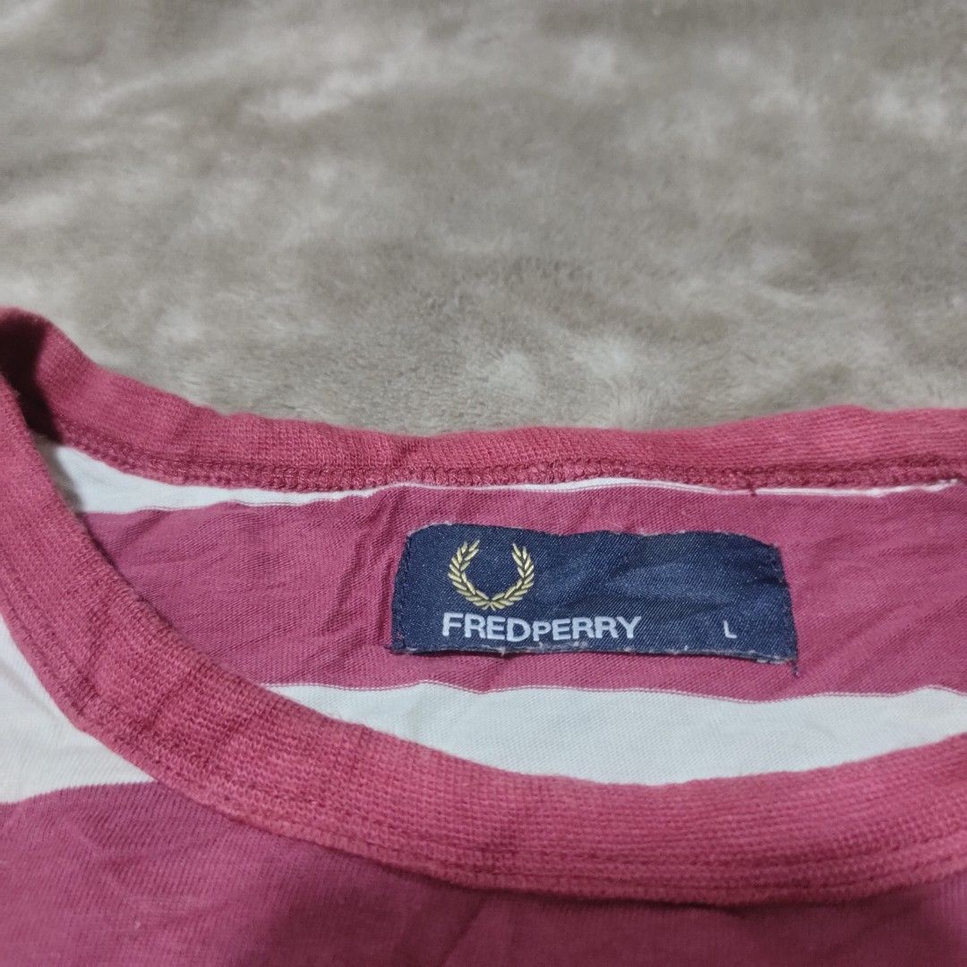 Fred Perry Striped T-Shirt Size L (Category: Tshirts & Polo Shirts ) located in Taguig. Submitted by actualizeboutique (Listing ID 1463864091, Image 3). Description: - Classic Fred Perry T-shirt - Features stylish horizontal stripes in pink and white - Comfortable 100% cotton fabric - Classic crew neck and short sleeves - Iconic embroidered Fred Perry laurel wreath logo on the chest - Ideal for everyday casual wear.
