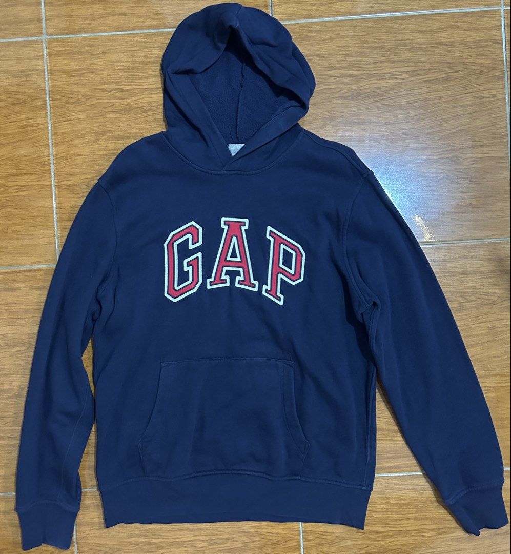 GAP Navy Blue Hoodie Sweatshirt (Category: Coats, Jackets and Outerwear) located in Valenzuela. Submitted by everydaysale_deni (Listing ID 1463881203, Image 1). Description: - Iconic white and red GAP logo across the chest - Features a front kangaroo pocket - Ideal for everyday casual wear.