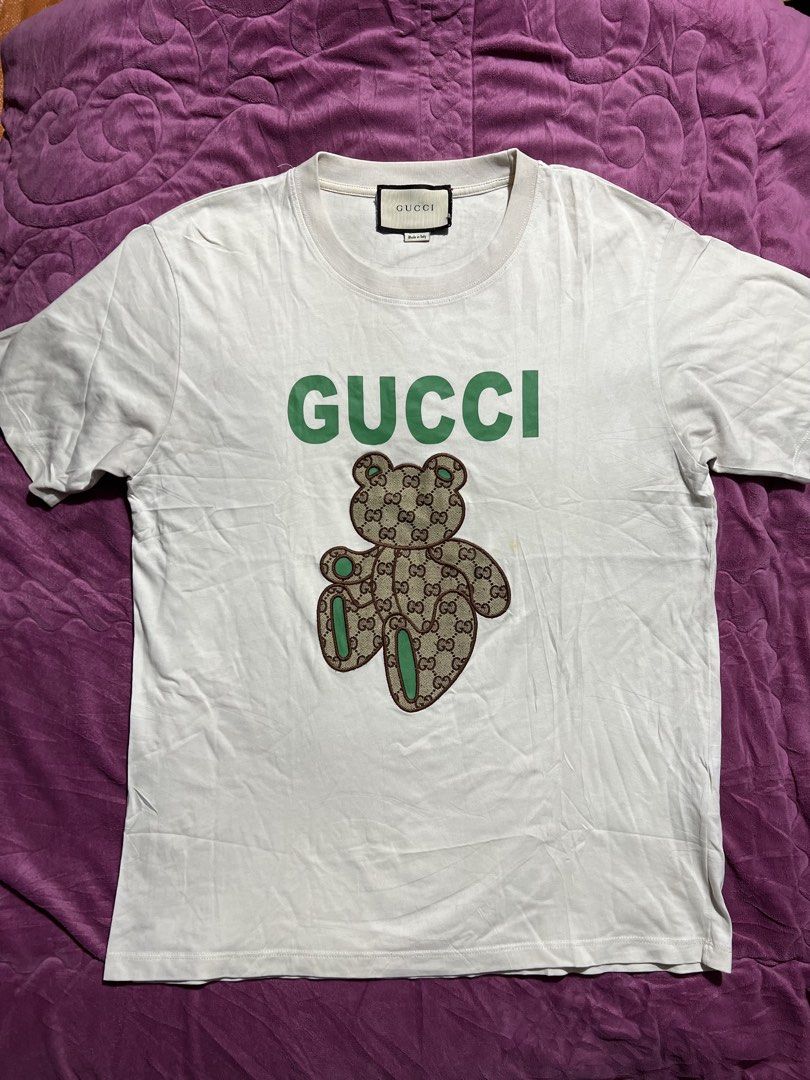 Gucci White T-Shirt with Bear Logo (Category: Shirts) located in Tagoloan. Submitted by rainebutro69475 (Listing ID 1463898676, Image 2). Description: - Authentic White Gucci T-Shirt - Features iconic green Gucci logo - Adorable teddy bear graphic with GG pattern - Made in Italy - A must-have for any Gucci enthusiast.