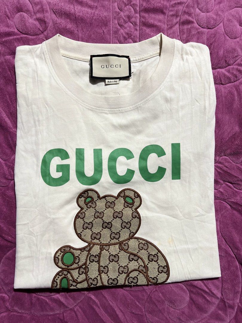 Gucci White T-Shirt with Bear Logo (Category: Shirts) located in Tagoloan. Submitted by rainebutro69475 (Listing ID 1463898676, Image 1). Description: - Authentic White Gucci T-Shirt - Features iconic green Gucci logo - Adorable teddy bear graphic with GG pattern - Made in Italy - A must-have for any Gucci enthusiast.