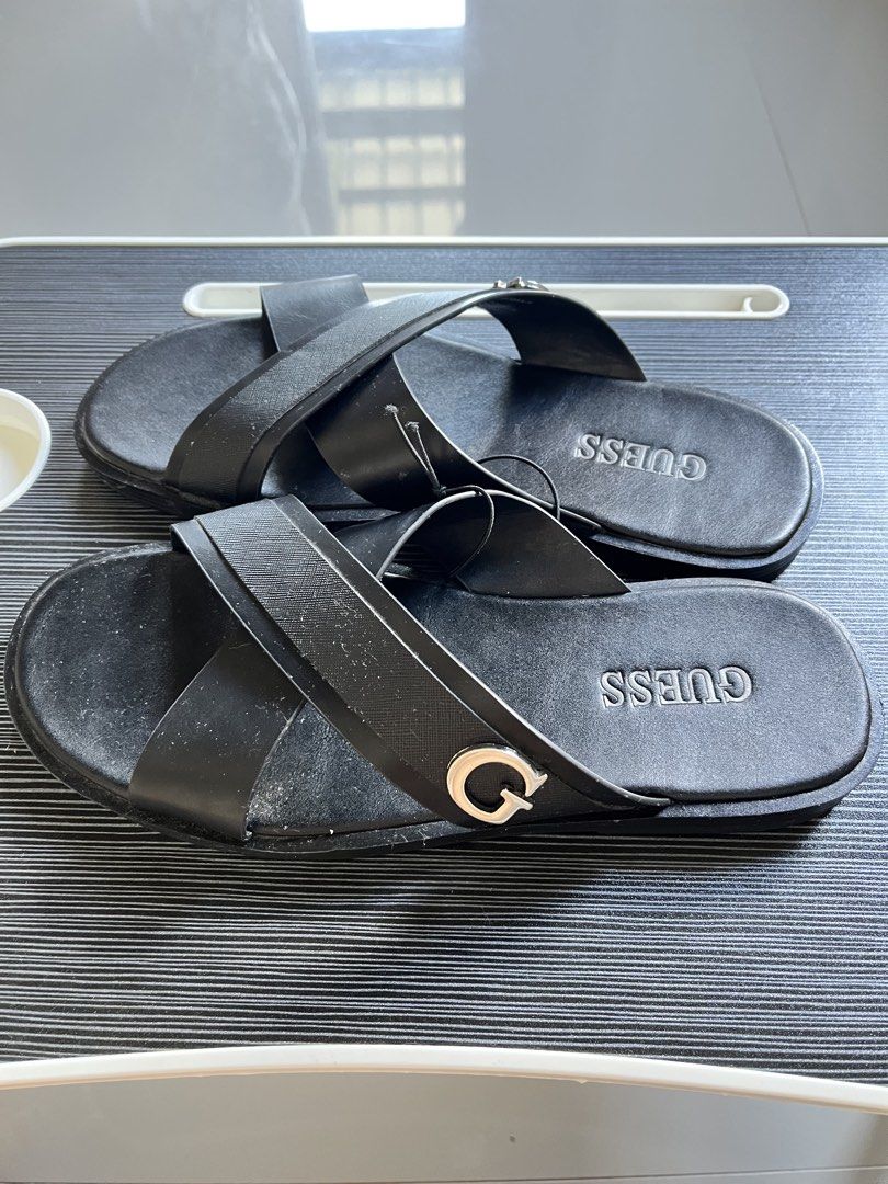 GUESS Black Cross Strap Slides Sandals (Category: Flats & Sandals) located in Adams. Submitted by m1k3yl (Listing ID 1463818404, Image 1). Description: - Stylish black GUESS slides - Features a chic criss-cross strap design - Embossed GUESS logo on the insole - Accentuated with a metal G logo detail on the strap - Convenient slip-on style for effortless wear - Ideal for everyday casual outings.
