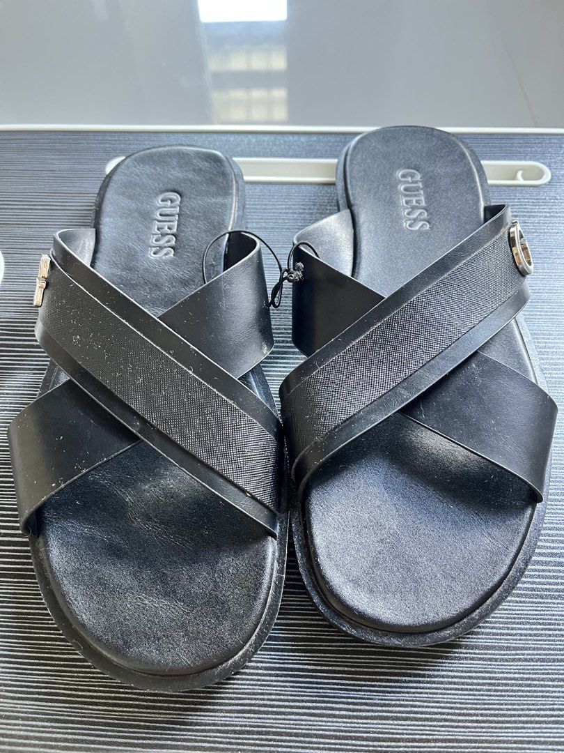 GUESS Black Cross Strap Slides Sandals (Category: Flats & Sandals) located in Adams. Submitted by m1k3yl (Listing ID 1463818404, Image 2). Description: - Stylish black GUESS slides - Features a chic criss-cross strap design - Embossed GUESS logo on the insole - Accentuated with a metal G logo detail on the strap - Convenient slip-on style for effortless wear - Ideal for everyday casual outings.