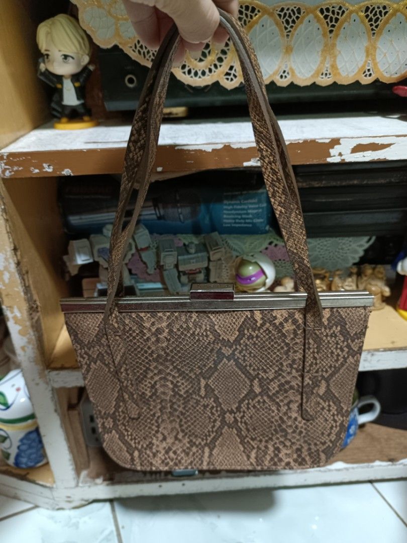 Guess Brown Snake Print Clasp Shoulder Bag (Category: Shoulder Bags) located in Manila. Submitted by caaths_collection (Listing ID 1463850361, Image 2). Description: - Cute brown bag with a trendy snake print pattern. - Features a secure and stylish metal clasp closure. - Matching snake print straps for a cohesive look. - Ideal size for carrying your essentials. - Perfect for a night out or to elevate your everyday style..