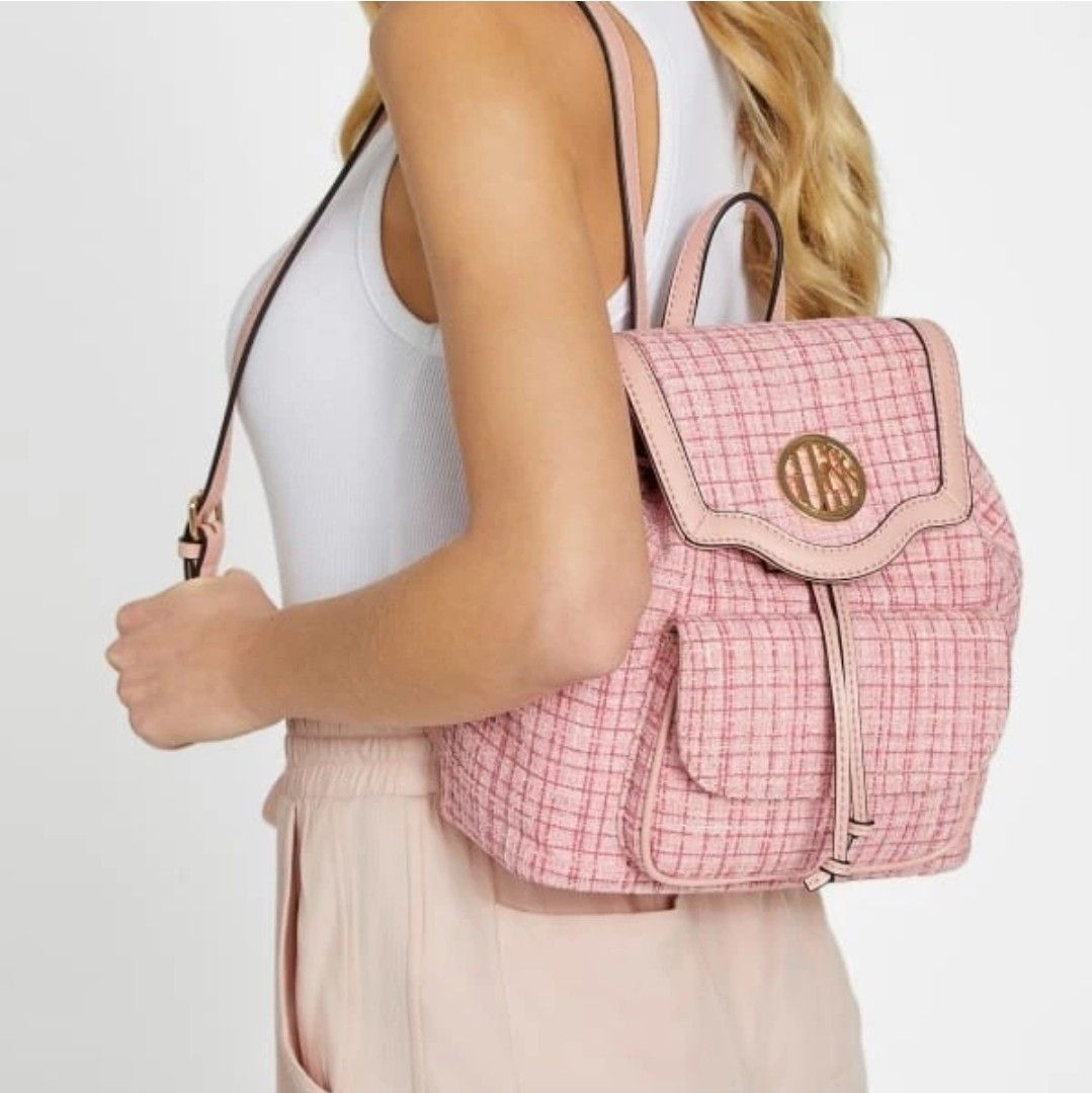 Guess Pink Tweed Backpack with Leather Trim (Category: Backpacks) located in Santa Rosa. Submitted by BerrieBlossom (Listing ID 1463881360, Image 2). Description: - Cute pink tweed backpack from Guess - Features a drawstring closure and flap top - Adorned with a gold Guess logo - Two front pockets with secure snap closures - Adjustable shoulder straps for comfort - Ideal for everyday wear or a stylish night out.