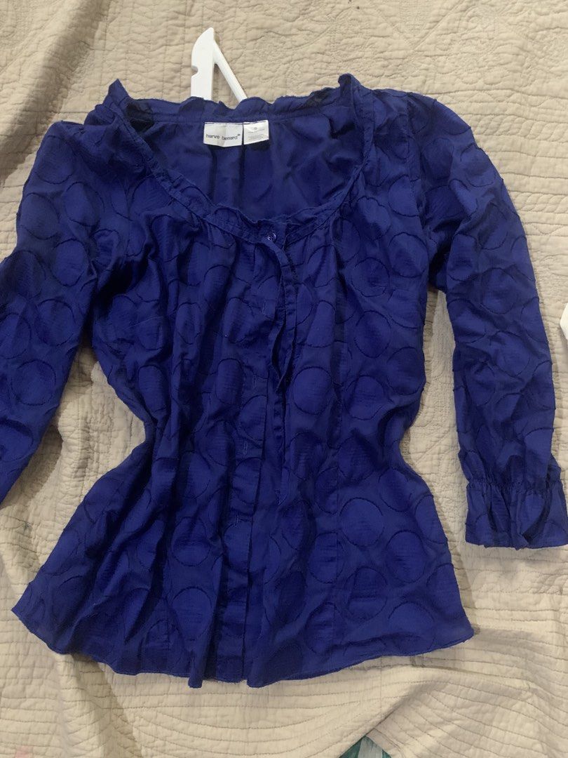 Harve Benard Blue Textured Button-Up Blouse (Category: Blouses) located in Manila. Submitted by spaceshop12345 (Listing ID 1463806971, Image 1). Description: - Blue long-sleeve blouse from Harve Benard - Features a unique textured circle pattern all over - Button-up front for adjustable styling - Elegant ruffled neckline adds a feminine touch - Ruffled cuffs on the sleeves for added detail - Perfect for pairing with jeans or skirts - Suitable for