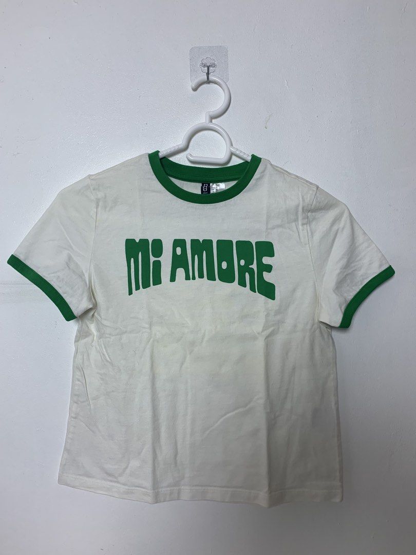 H&M Divided White 'Mi Amore' Ringer Tee (Category: Shirts) located in San Pedro. Submitted by reginacarla (Listing ID 1463767573, Image 1). Description: - H&M Divided white ringer tee - Features 'Mi Amore' graphic in green - Green trim on collar and sleeves - Cropped style - Ideal for casual wear RFS: Decluttering ✨ ₱200 negotiable 😊 📦 SF/delivery fee c/o buyer 🚚 Lalamove / Grab / J&T available 💳 GCash.