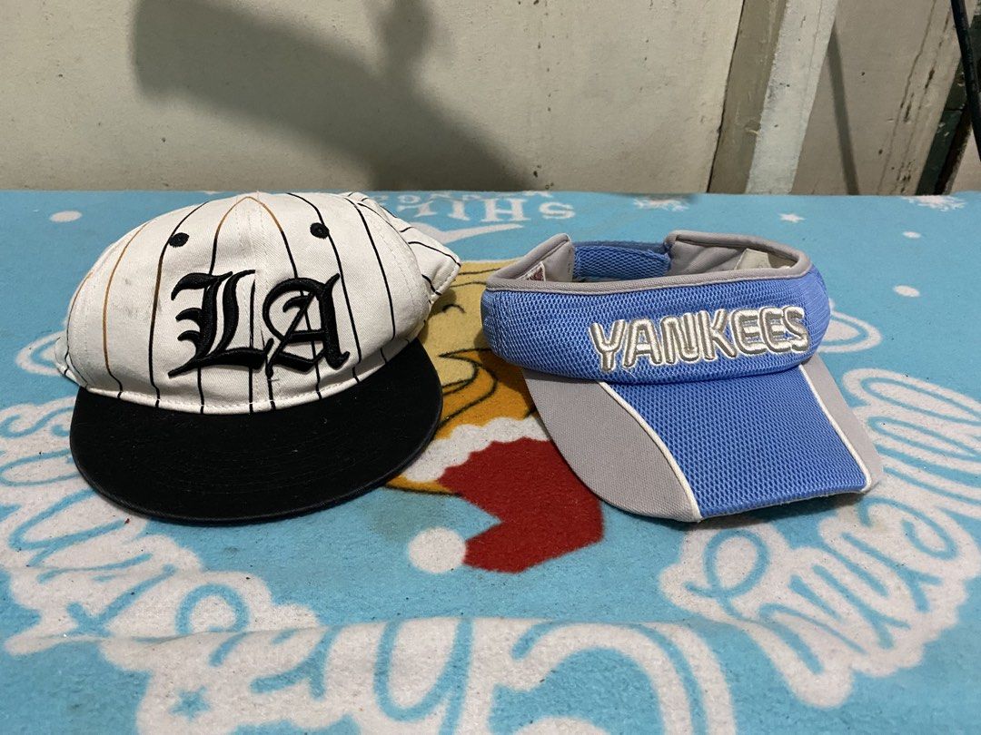 H&M LA Cap & Yankees Visor Bundle (Category: Babies & Kids Fashion) located in Manila. Submitted by resi.diaz (Listing ID 1463838050, Image 1). Description: - 6-8 years old - Bundle includes 2 headwear items: - H&M Cap: White with black pinstripes, 'LA' design, black brim, adjustable strap. - New York Yankees Visor: Blue and grey colorway. - Both are great for casual outings or showing team spirit..