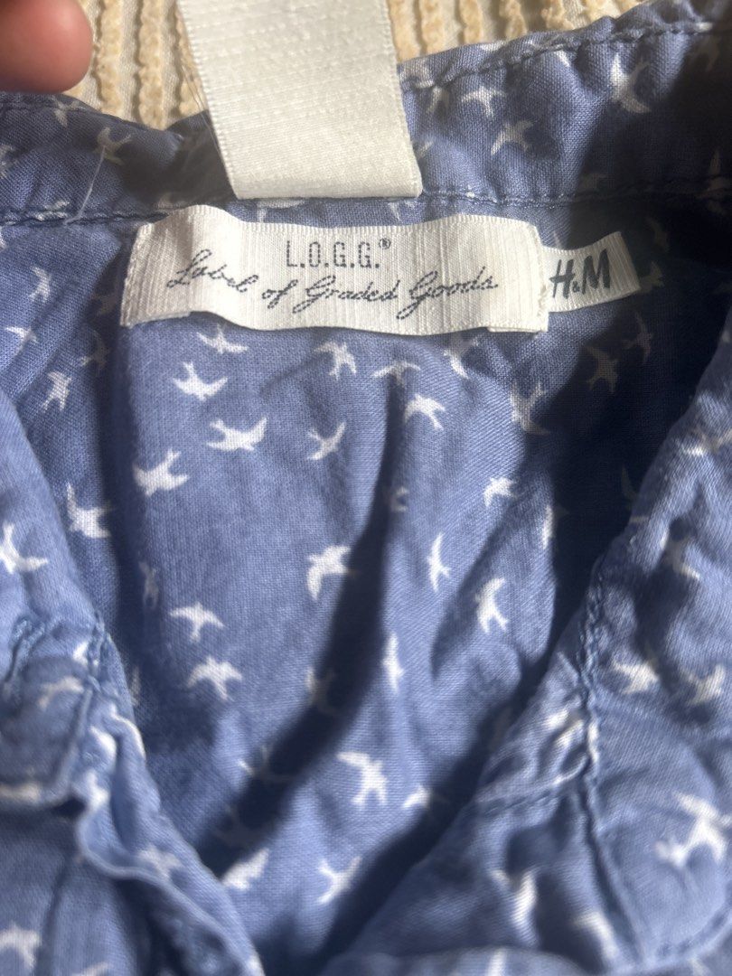 H&M LOGG Blue Bird Print Button-Up Shirt (Category: Tshirts & Polo Shirts ) located in Lal-Lo. Submitted by pureearth_8c747c (Listing ID 1463784650, Image 3). Description: - Blue button-up shirt - Adorable all-over white bird print - Short sleeves with optional roll-up tabs - Two chest pockets with button closure - Made in Bangladesh - Ideal for casual outfits.