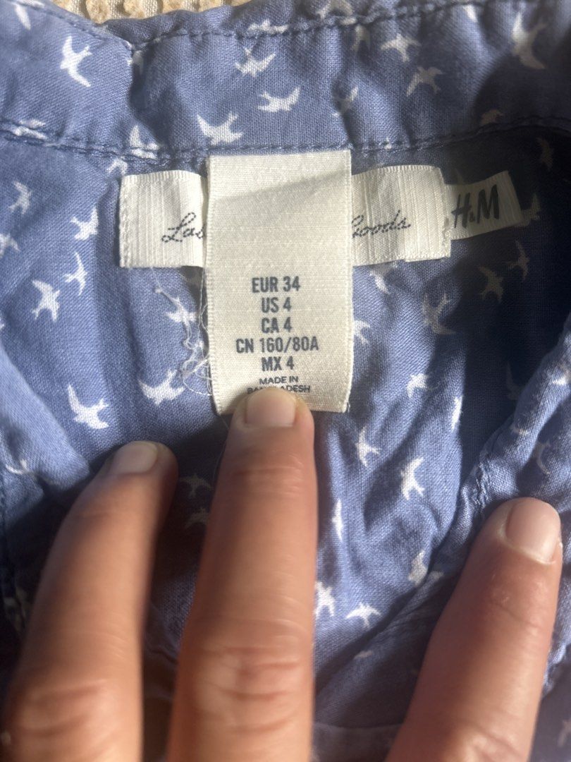 H&M LOGG Blue Bird Print Button-Up Shirt (Category: Tshirts & Polo Shirts ) located in Lal-Lo. Submitted by pureearth_8c747c (Listing ID 1463784650, Image 2). Description: - Blue button-up shirt - Adorable all-over white bird print - Short sleeves with optional roll-up tabs - Two chest pockets with button closure - Made in Bangladesh - Ideal for casual outfits.