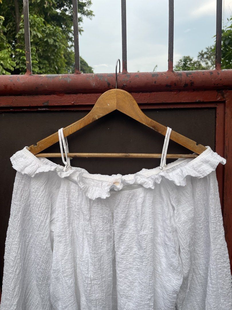 H&M Smocked off shoulder (white) (Category: Longsleeves) located in Quezon City. Submitted by thegardenoffinds (Listing ID 1463829168, Image 3). Description: - Large on tag - Cute white off-shoulder top - Textured fabric with ruffled neckline - Long puff sleeves with buttoned cuffs - Adjustable spaghetti straps - Versatile: pairs well with high-waisted pants or skirts - Ideal for casual days or nights out with friends.