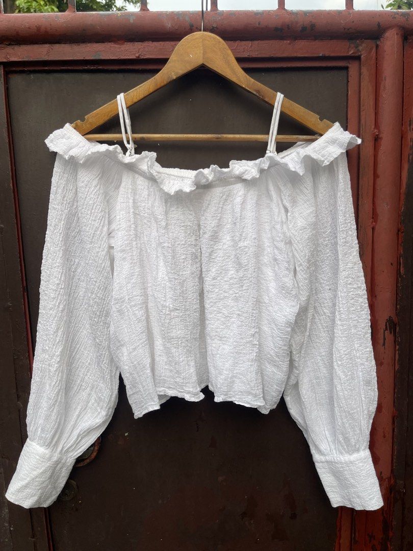 H&M Smocked off shoulder (white) (Category: Longsleeves) located in Quezon City. Submitted by thegardenoffinds (Listing ID 1463829168, Image 2). Description: - Large on tag - Cute white off-shoulder top - Textured fabric with ruffled neckline - Long puff sleeves with buttoned cuffs - Adjustable spaghetti straps - Versatile: pairs well with high-waisted pants or skirts - Ideal for casual days or nights out with friends.