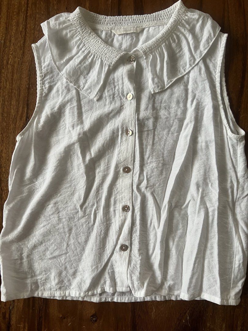 Intique White Sleeveless Peter Pan Collar Button Up Top (Category: Blouses) located in Angeles City. Submitted by msr093 (Listing ID 1463805187, Image 1). Description: - White sleeveless top - Peter Pan collar with smocked detail - Button-up front with pearl-like buttons - Linen blend fabric look - Ideal for casual wear or layering.