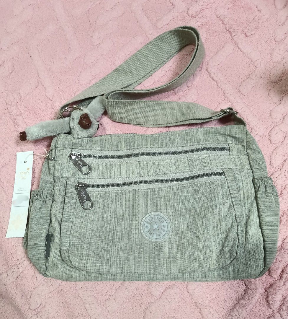 Kipling Crossbody Bag |Light Grey | Original Monkey Charm (Category: Cross-body Bags) located in Santa Maria. Submitted by anne_s.list (Listing ID 1463819764, Image 1). Description: Decluttering! 💚 Selling my Kipling crossbody/shoulder bag in a beautiful grey shade. ✨ Condition: 9/10 • Minimal signs of use • Minimal dirt inside • Zippers & strap are in good working condition • Complete with signature Kipling monkey charm • Multiple zip compartme
