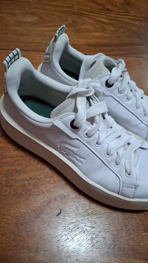Lacoste White Leather Sneakers (Category: Sneakers) located in Manila. Submitted by girlyukay (Listing ID 1463862747, Image 3). Description: - White leather low-top sneakers from Lacoste - Classic lace-up closure - Features iconic Lacoste crocodile logo on side and heel tab - Perfect for everyday casual wear.