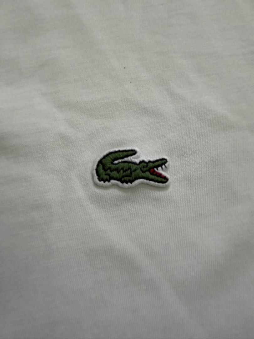 Lacoste White T-Shirt for men’s (Category: Tshirts & Polo Shirts ) located in Quezon City. Submitted by vaniefiel (Listing ID 1463780445, Image 2). Description: For Sale! Authentic - Lacoste t-shirt - Iconic green crocodile logo embroidered on chest - Made from 100% cotton for ultimate comfort - Regular fit for a comfortable silhouette - Tag indicates origin from Hong Kong - issue pinhole upper left shoulder - Check pictures for actual size dimen