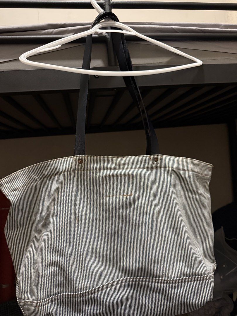 Levi's Striped Denim Tote Bag (Category: Tote Bags) located in Iloilo. Submitted by juca.sale (Listing ID 1463877787, Image 2). Description: - Classic Levi's tote bag - Blue and white pinstripe denim material - Black leather straps - Multiple exterior pockets for easy access - Interior pocket with branded Levi's tag - Spacious and durable design - Perfect for everyday use or travel.