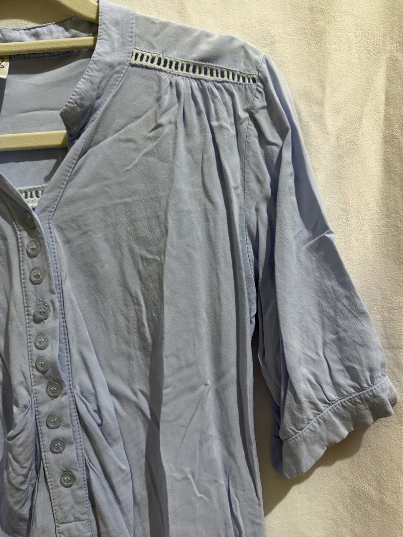 Light Blue Blouse (Category: Blouses) located in Paranaque City. Submitted by declutternsell.729 (Listing ID 1463774589, Image 2). Description: - Light blue V-neck blouse - Button details down the front - Gathered detail at the sleeves - Decorative trim across shoulders and back - Versatile for casual or dressy occasions - Comfortable and breathable fabric FITS SMALL TO MEDIUM.