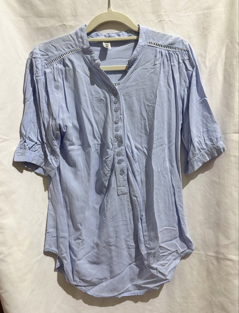 Light Blue Blouse (Category: Blouses) located in Paranaque City. Submitted by declutternsell.729 (Listing ID 1463774589, Image 1). Description: - Light blue V-neck blouse - Button details down the front - Gathered detail at the sleeves - Decorative trim across shoulders and back - Versatile for casual or dressy occasions - Comfortable and breathable fabric FITS SMALL TO MEDIUM.