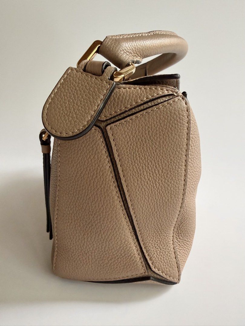 Loewe Puzzle Small in Sand (Category: Luxury Bags & Wallets) located in Quezon City. Submitted by lian_closet (Listing ID 1463770243, Image 3). Description: Loewe Puzzle Small in Sand Best Price: ₱76,000 Preloved Comes with Detachable Strap, Dust Bag & LegitGrails Authenticity Certificate Preloved Rating: 8.2/10 Excellent but shows signs of wear Cracks on leather by the handle Interior is clean.