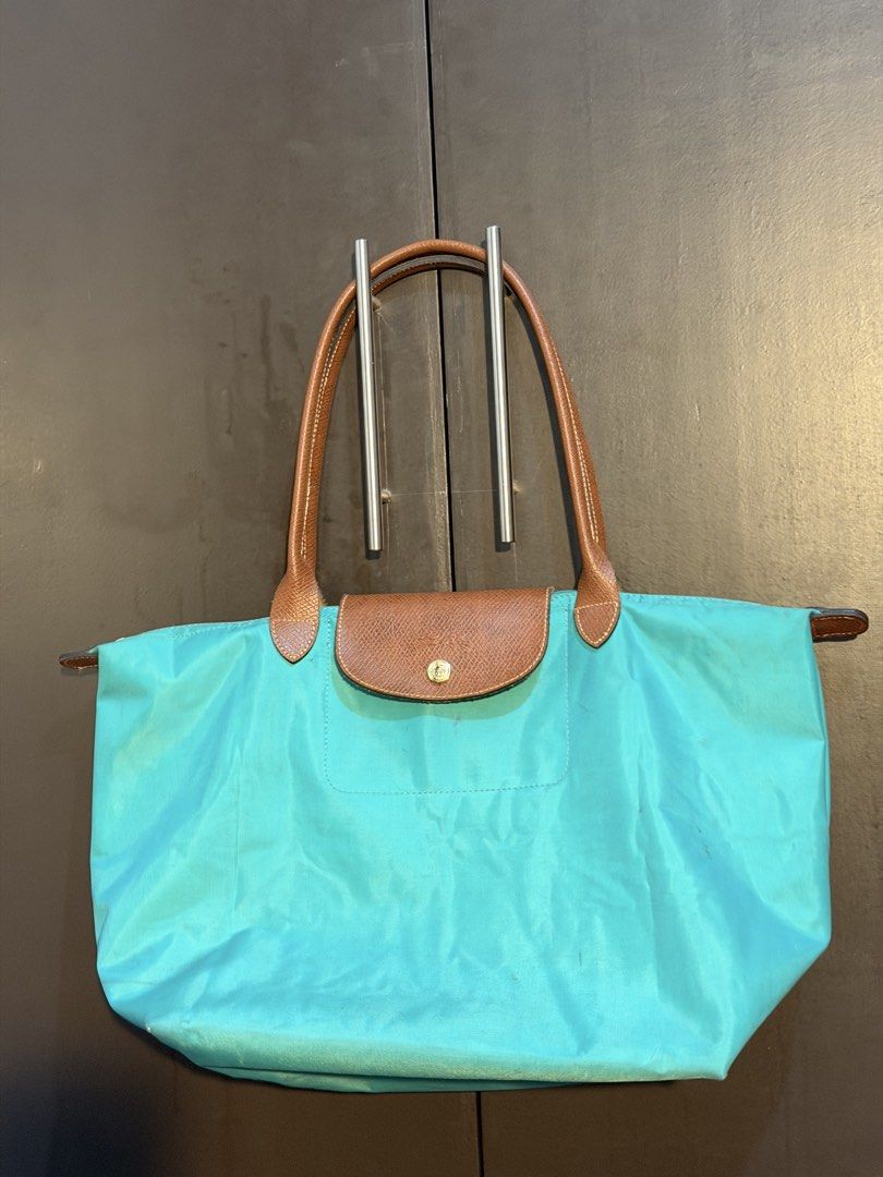 Longchamp Le Pliage Tote Bag (Category: Luxury Bags & Wallets) located in Manila. Submitted by jlcvinci (Listing ID 1463880216, Image 2). Description: - Classic Longchamp tote bag - Teal nylon body - Brown leather handles and trim - Folds flat for easy storage - Great everyday bag for essentials - Handles show some wear - Bag itself is in good shape.