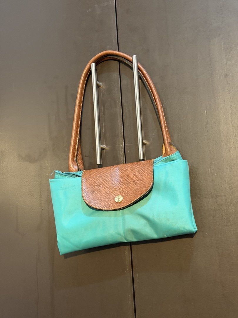 Longchamp Le Pliage Tote Bag (Category: Luxury Bags & Wallets) located in Manila. Submitted by jlcvinci (Listing ID 1463880216, Image 1). Description: - Classic Longchamp tote bag - Teal nylon body - Brown leather handles and trim - Folds flat for easy storage - Great everyday bag for essentials - Handles show some wear - Bag itself is in good shape.