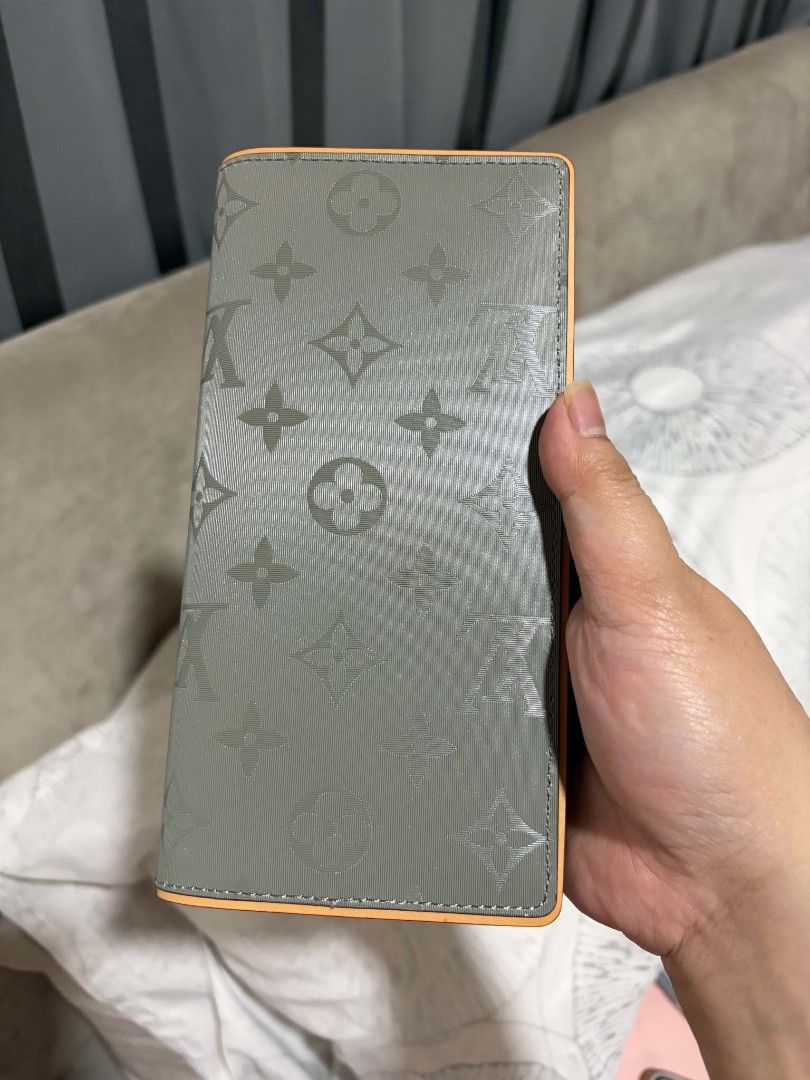 Louis Vuitton Monogram Long Wallet (Category: Luxury Bags & Wallets) located in Polomolok. Submitted by legadad94559 (Listing ID 1463923291, Image 1). Description: - Authentic Louis Vuitton long wallet - Stylish grey monogram canvas with vibrant orange trim - Ample card slots for all your cards - Convenient zippered compartment for secure storage - Immaculate interior, well-maintained - Ideal for keeping your essentials neatly organized.