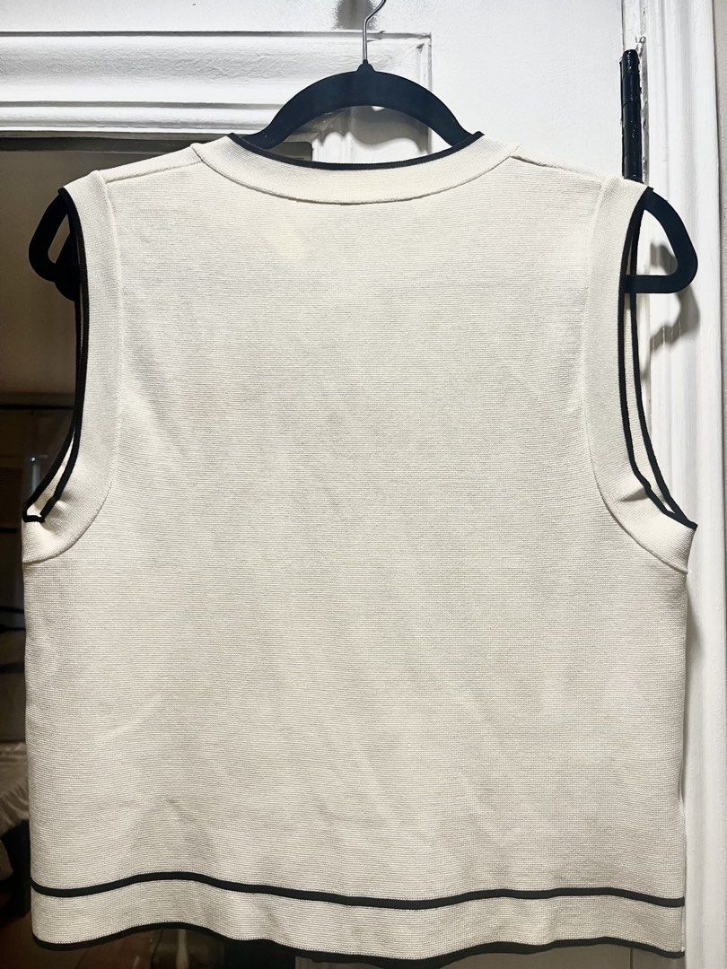 MANGO Cream Knit Vest with Black Trim (Category: Sleeveless) located in Pasig City. Submitted by thestoragestudio (Listing ID 1463812695, Image 3). Description: - Cream knit vest from Mango - Size: Medium - Black trim accents on neckline, armholes, and hem - Two front pockets with black trim - Button-up front with black buttons - Made in Turkey.
