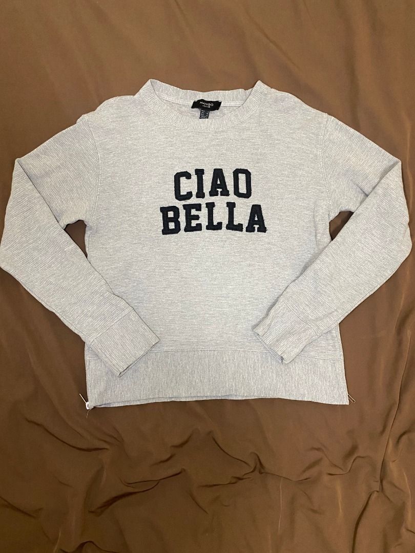 Mango Jeans Grey 'Ciao Bella' Sweater (Category: Longsleeves) located in San Pablo. Submitted by kisha_santonia (Listing ID 1463871008, Image 1). Description: - Grey sweater from Mango Jeans - Features 'Ciao Bella' text on the front - Side zippers for added style and adjustability - Ribbed texture throughout for a cozy feel - Size: Small (S).