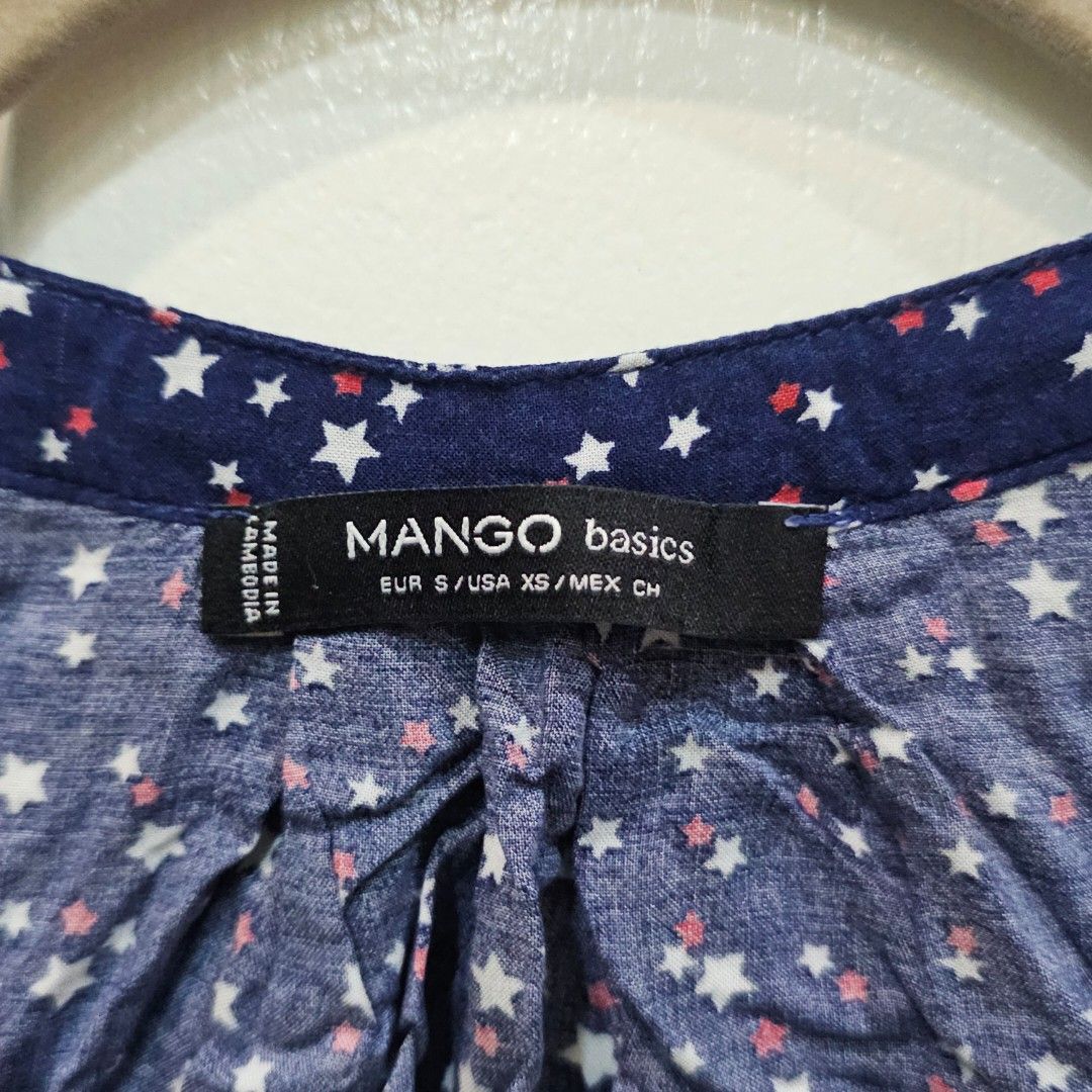 Mango Navy Star Print Sleeveless Top (Category: Sleeveless) located in Makati City. Submitted by goldenbird.001 (Listing ID 1463842541, Image 2). Description: - Navy blue sleeveless top - White and red star print - V-neck design - Ruched detail at the front - Lightweight fabric, ideal for warm weather - Versatile for dressing up or down.