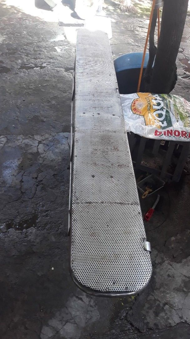 Metal Perforated Bench (Category: Office Furniture & Fixtures) located in Quezon City. Submitted by madelrivera (Listing ID 1463837684, Image 1). Description: - Long metal bench with a perforated surface - Sturdy metal legs for excellent support - Ideal for outdoor or industrial environments - Shows some signs of wear, but remains fully functional - Versatile for seating or as a utility surface.