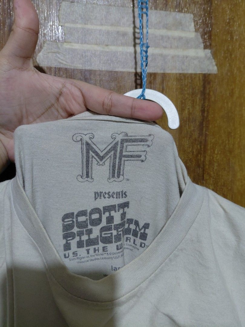 MF DOOM Scott Pilgrim vs. The World T-Shirt (Category: Shirts) located in Imus. Submitted by frootiloots4103 (Listing ID 1463750786, Image 2). Description: - MF DOOM Scott Pilgrim vs. The World graphic tee - Features the iconic bomb design - Tag size: Large - Material: Comfortable cotton - Ideal for fans of the movie or comic Large can fit XL OPEN FOR NEGO (best if aspack) 📍Imus, Cavite 4103 Can do meetups within Imus Area 🚚 J&T or Lalamove 📨 