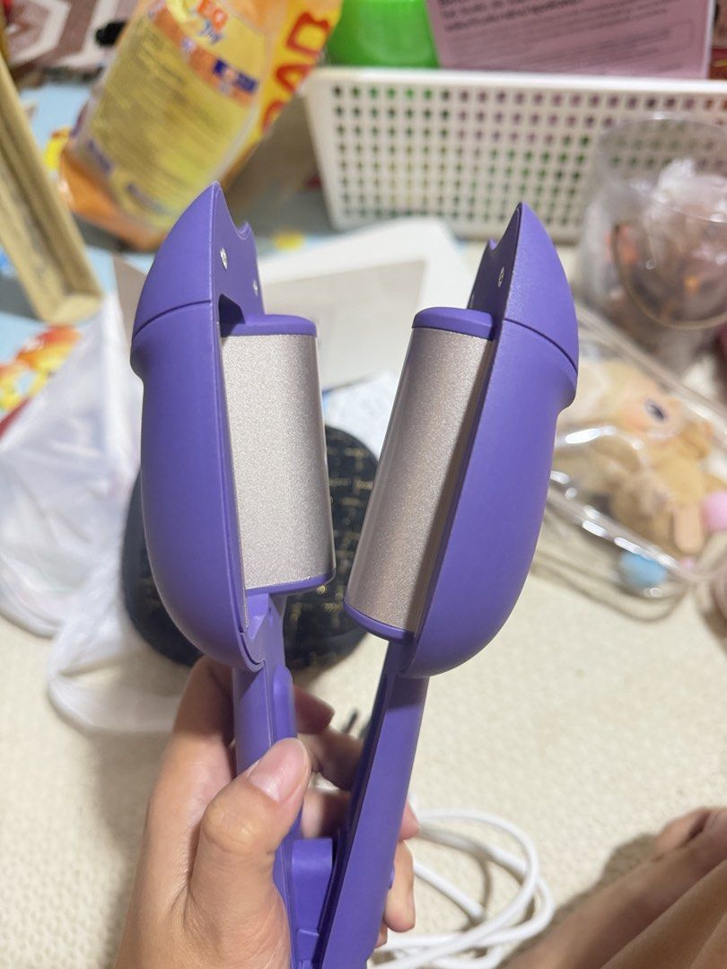 Mini Curler (purple) (Category: Hair) located in Las Pinas. Submitted by sugaaarr (Listing ID 1463891659, Image 1). Description: - Adorable purple mini hair curler - Features a cute paw print design on the back - 'liangyating' brand name on the front - Includes a power button and battery indicator lights - Ideal for travel and quick hair touch-ups.