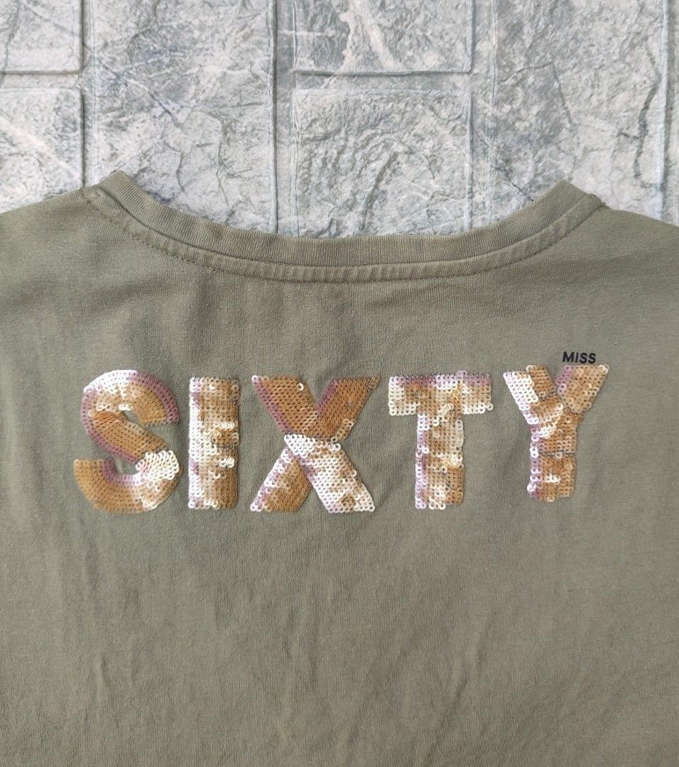 Miss Sixty Olive Green Sequined "SIXTY" T-shirt (Category: Shirts) located in Bayambang. Submitted by mon10192816 (Listing ID 1463751925, Image 3). Description: - Width 18 - Length 23¼ - Olive green V-neck t-shirt by Miss Sixty. - "SIXTY" spelled out in vibrant sequins on the back. - Small rose and script logo on the front left chest. - Made from a comfortable cotton blend. - Perfect for a stylish casual outfit..