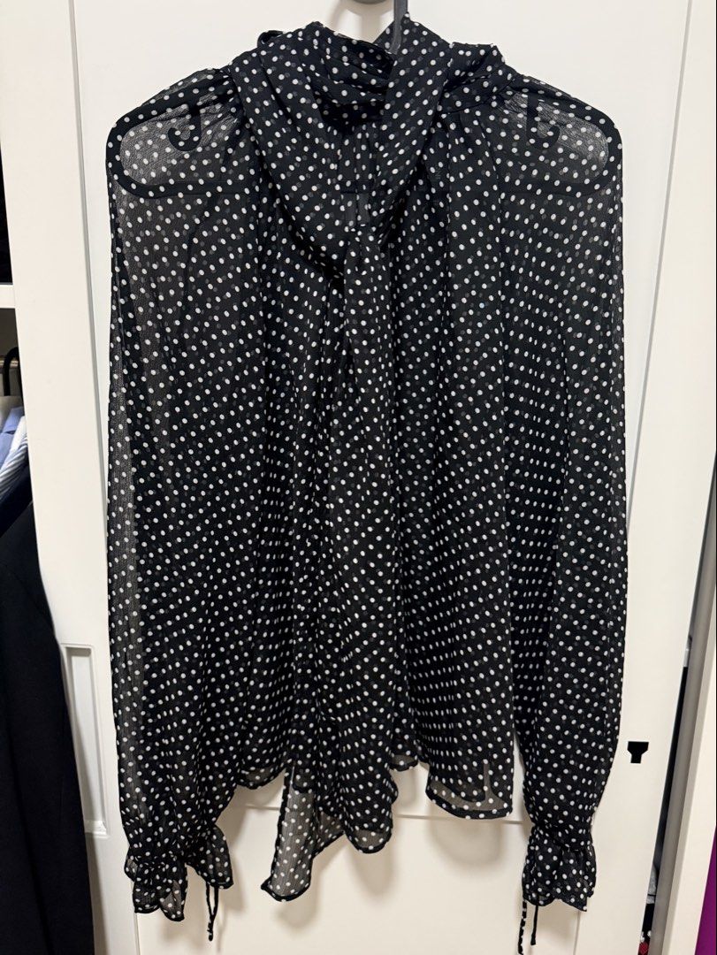 MNG Black Polka Dot High Neck Sheer Blouse (Category: Blouses) located in Manila. Submitted by .yansells (Listing ID 1463928971, Image 3). Description: - Chic black sheer blouse - Adorable white polka dot pattern - Elegant high neckline with tie detail - Long sleeves with ruffled, tieable cuffs - Lightweight and flowy material - Perfect for layering or as a standalone statement piece - Fits M-semi XL.