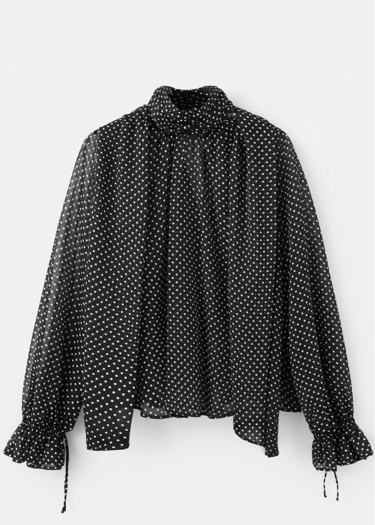 MNG Black Polka Dot High Neck Sheer Blouse (Category: Blouses) located in Manila. Submitted by .yansells (Listing ID 1463928971, Image 1). Description: - Chic black sheer blouse - Adorable white polka dot pattern - Elegant high neckline with tie detail - Long sleeves with ruffled, tieable cuffs - Lightweight and flowy material - Perfect for layering or as a standalone statement piece - Fits M-semi XL.
